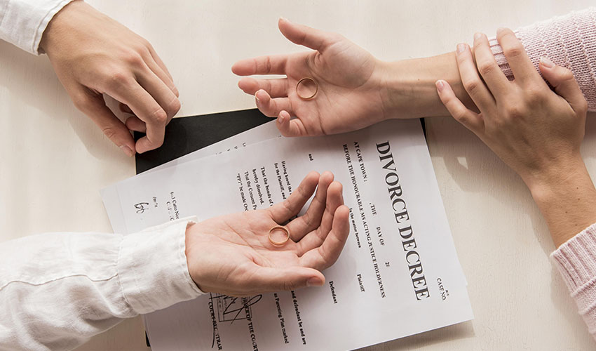 hands with divorce decree close up - inheritance and divorce