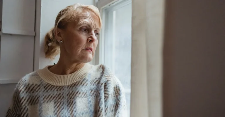 Eldery woman looking out the window